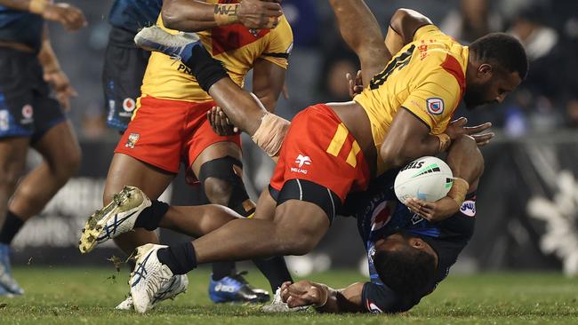 Mikaele Ravalawa is dumped in a horror tackle by Papua New Guinea’s McKenzie Yei. Picture: Getty