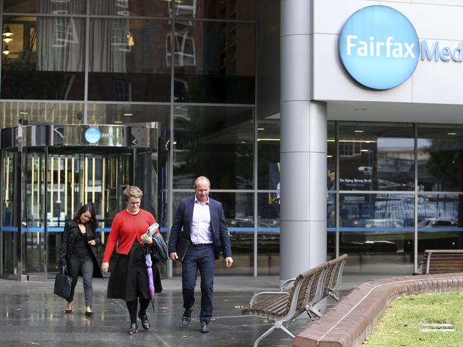 People leave the Farifax offices in Sydney, Wednesday, May 3, 2017. Fairfax said it would cut 125  editorial jobs at its Australian newspapers after New Zealand regulators rejected a merger there that Fairfax said would save money and jobs. (AP Photo/Rick Rycroft)