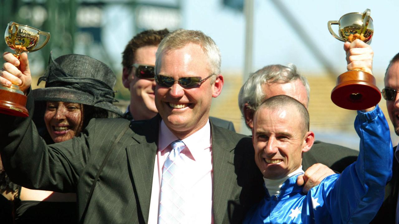 NOVEMBER 4, 2003 : Trainer David Hall & jockey Glen Boss hold respective trophies aloft at Flemington following victory in Melbourne Cup with racehorse Makybe Diva 04/11/03. Pic Craig Hughes. Turf / Trophy