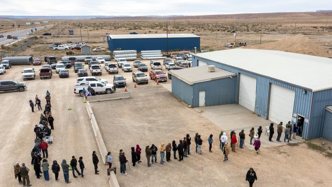 Voters wait in line to cast their ballots outside a polling station on the Navajo Nation in Chinle, Arizona.