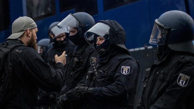 An anti-lockdown demonstrator talks to riot police during protests in Berlin. Picture: Getty Images