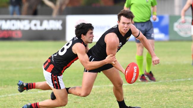 Trent Heffernan gets a handball away under pressure from ROC’s Tim Baccanello. Picture: AAP/Keryn Stevens