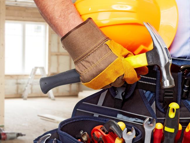 Builder handyman with construction tools. House renovation background.