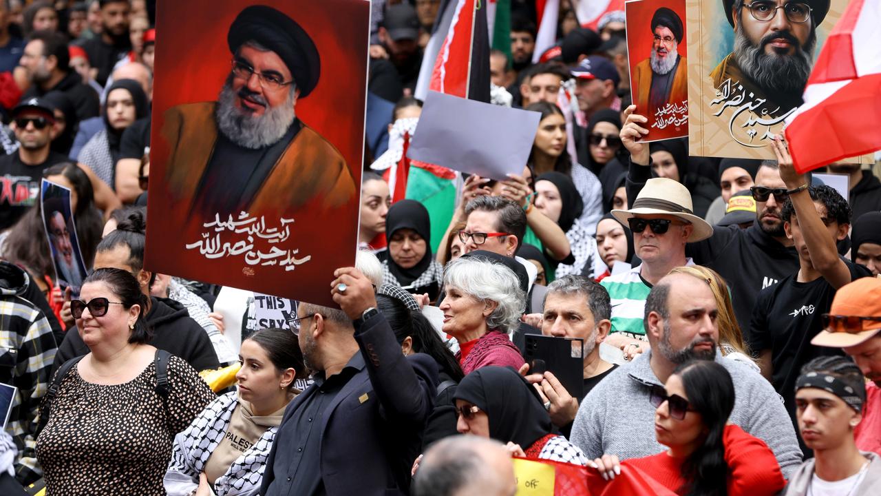 People hold up pictures of Hezbollah leader Hassan Nasrallah at a protest at Town Hall in Sydney. Picture: NewsWire / Damian Shaw