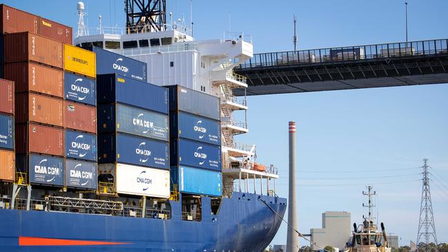 A Svitzer tug boat follows a container ship under the West Gate Bridge at the Port of Melbourne. Picture: Mark Stewart