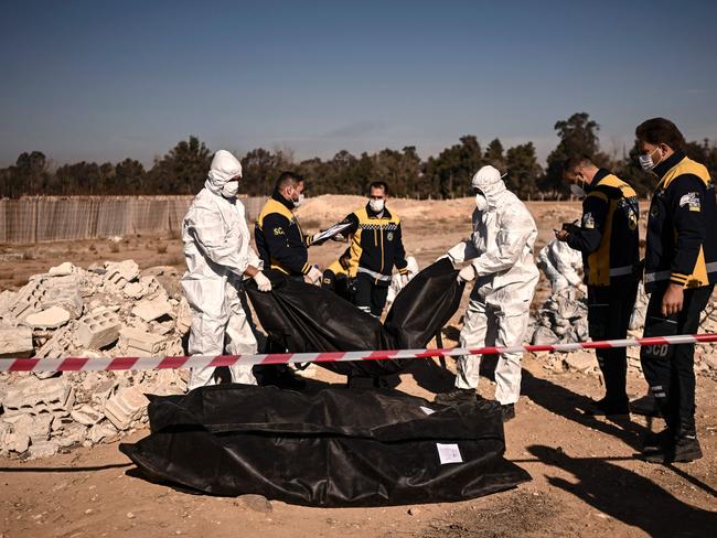 Members of Syria's White Helmets civil defence transport body-bags containing human remains that were recovered from a mass grave, in Damascus, on December 16, 2024. Picture: AFP