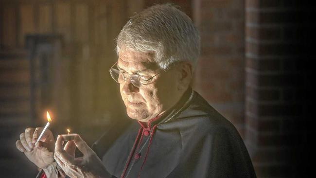 Reverened Canon Dr Gregory Jenks, dean of the Christ Church Cathedral in Grafton lights a candle in preparation for the vigil service to be held in the church. Picture: Adam Hourigan