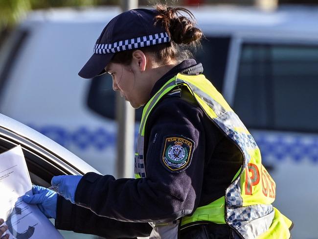 Police in the southern New South Wales (NSW) border city of Albury check cars crossing the state border from Victoria on July 8, 2020 after authorities closed the border due to an outbreak of COVID-19 coronavirus in Victoria. - With the city of Melbourne going into lockdown for the next six weeks, the entire state of Victoria will effectively be sealed off from the rest of the country with the state border to NSW closing on 08 July. (Photo by William WEST / AFP)