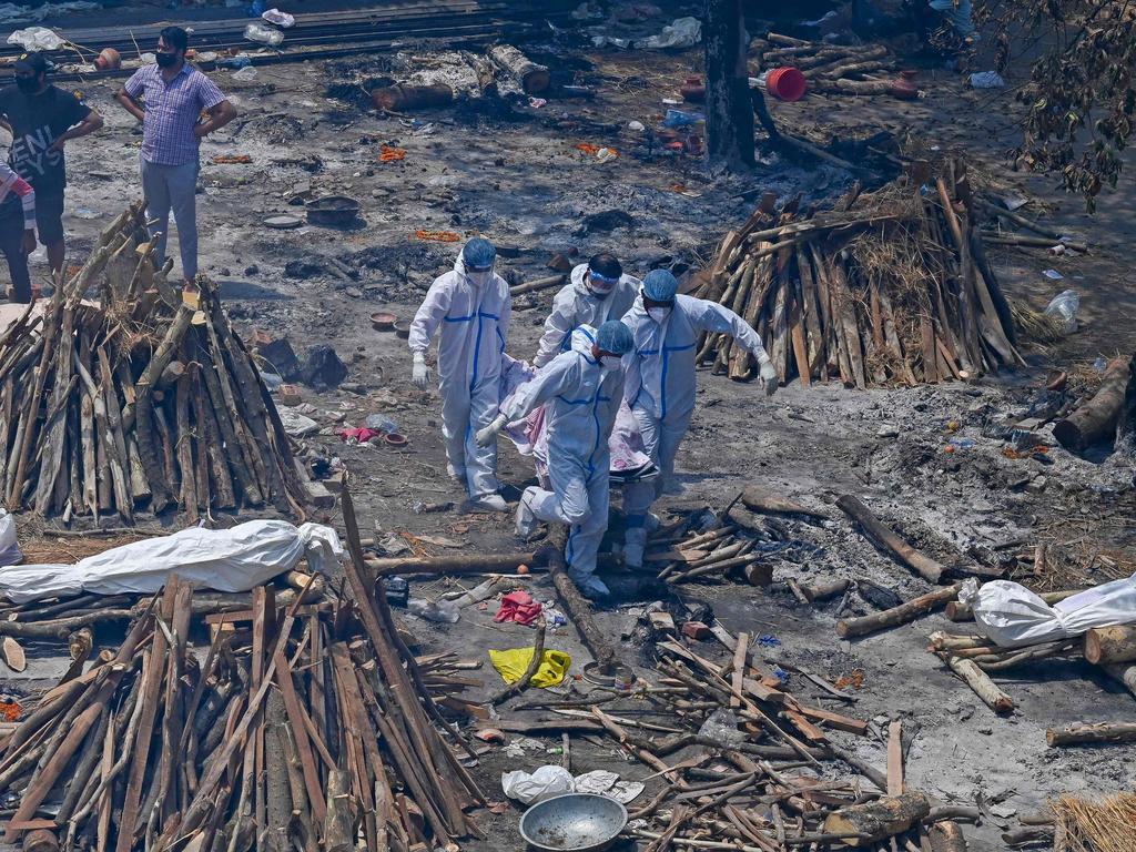 Family members and relatives perform the last rites amid the funeral pyres of victims who died of COVID-19. Picture: Prakash Singh/AFP