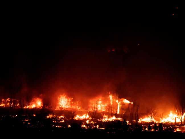 Flames engulf homes as the Marshall Fire spreads through a neighborhood in the town of Superior in Boulder County, Colorado on December 30, 2021. - Hundreds of homes are feared lost in fast-moving wildfires in the US state of Colorado, officials said Thursday, as flames tear through areas desiccated by a historic drought. At least 1,600 acres have burned in Boulder County, much of it suburban, with warnings that deaths and injuries were likely as the blaze engulfes hotels and shopping centers. Extreme winds topping 100 mph caused grass fires to quickly spread into the Colorado towns of Superior and Louisville resulting in the mandatory evacuation of over 30,000 residents. Colorado Governor Jared Polis has declared a state of emergency due to the grass fires in Boulder County. (Photo by Jason Connolly / AFP)