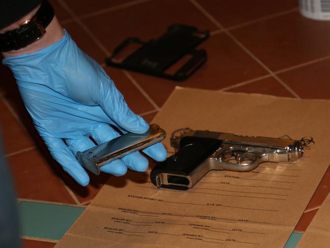 A police officer handles a cartridge and handgun / Picture: NSW Police Media