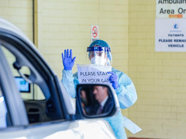 The first patient to use the new drive-thru coronavirus test station is attended to by nurses from his car at the Repat Hospital in Daw Park, March 10, 2020.