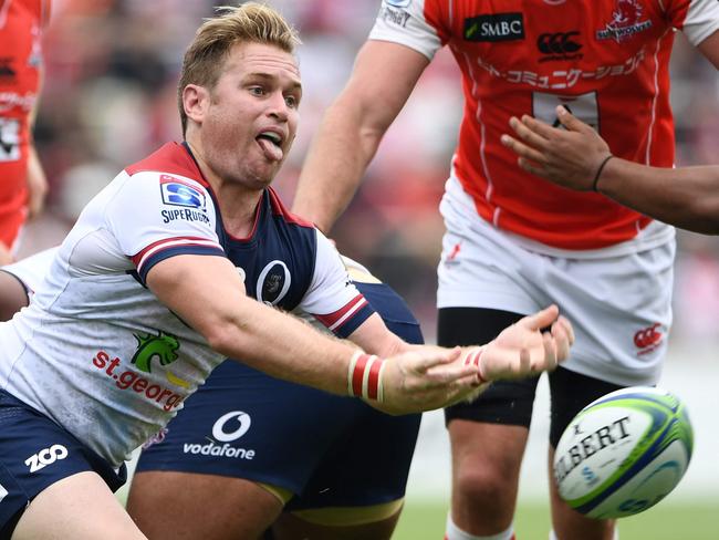 Reds' srum half Ben Lucas (L) takes the ball out of a scrum during the Round 13 Super Rugby match between the Sunwolves of Japan and the Reds of Australia at Prince Chichibu Memorial Stadium in Tokyo on May 12, 2018. / AFP PHOTO / Martin BUREAU