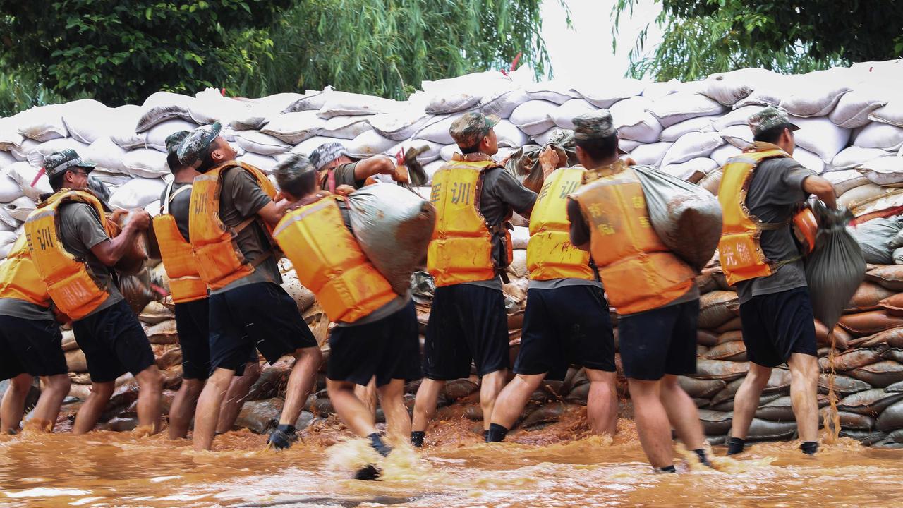 Chinese soldiers building an emergency levee near the Poyang Lake to contain flooding due to torrential rains in Jiujiang in China's central Jiangxi province. Picture: STR/AFP