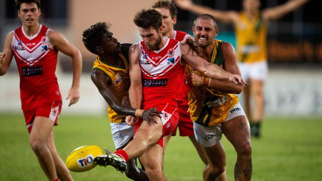 NTFL Round 7: St Mary's v Waratah at TIO Stadium. William Hetherington gets a boot to the footy under immense pressure from the Saints in the final quarter. Picture: Che Chorley