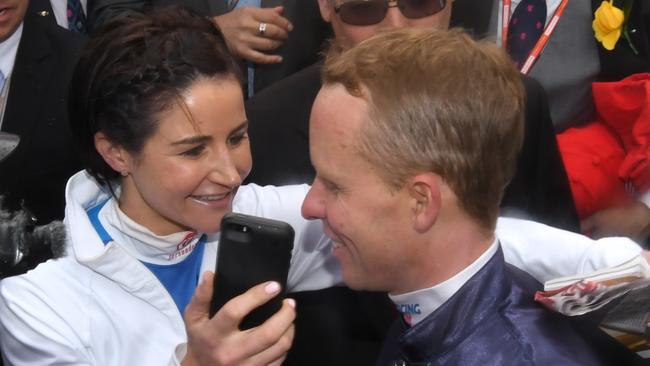 Kerrin McEvoy’s sister-in-law Michelle Payne hands the jockey her phone to talk to his wife, Cathy, after Almandin’s win on Tuesday.