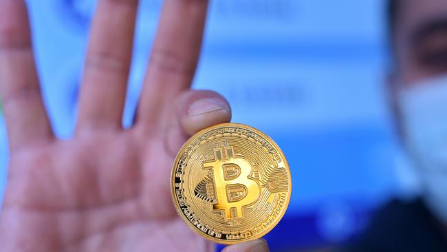 A man holds a physical imitation of a Bitcoin at a crypto currency in Istanbul. Picture: Ozan Kose/AFP