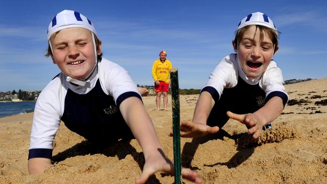 Long Reef Surf Life Saving Club. Adam Kent (nipper chairman) watches his sons (L-R) Liam, 11, and; Cooper, 8, practise flags.