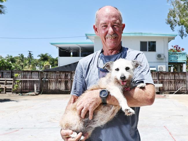 After having their Holloways Beach house badly damaged in last year's flood, Chris Tress and his wife have made the decision to demolish the existing structure and build a new, smaller kit home on the existing slab. The couple hope to have their new home completed by June.  Chris Tress stands on the site of his old home with his dog Peg. Picture: Brendan Radke