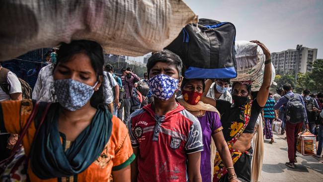 Migrant workers heading back to their villages queue up to enter a railway station in Mumbai on Wednesday. Picture: Getty Images