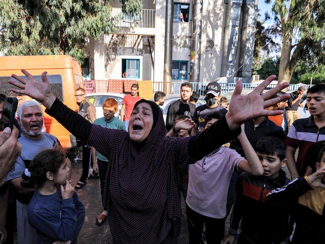 A woman reacts as people gather at the site of the Ahli Arab hospital in central Gaza. Picture: AFP