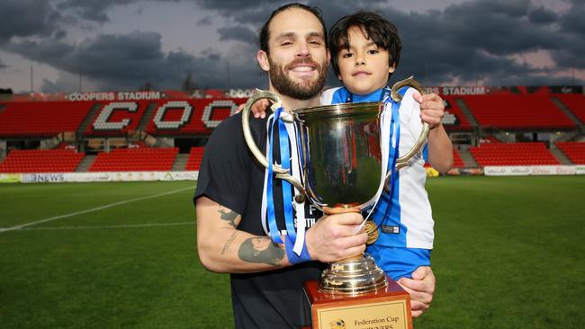 Ricardo Da Silva celebrates Adelaide Olympic’s FFA Cup SA final victory with his son. Picture: AAP/Emma Brasier