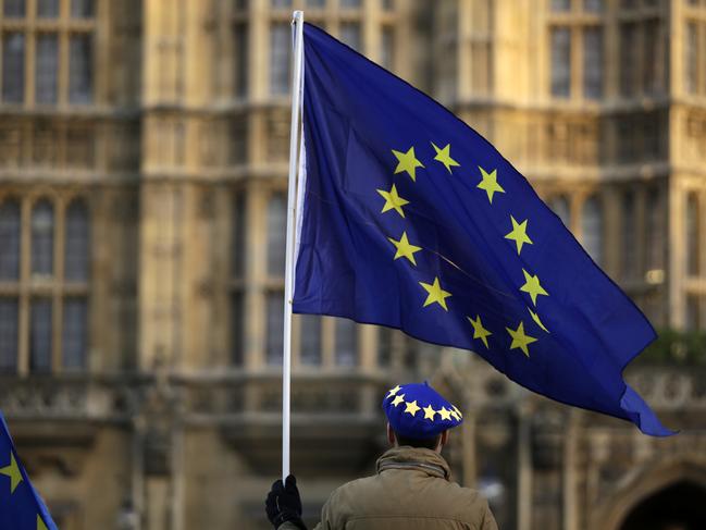 A pro-Europe demonstrator holds a flag outside the Houses of Parliament in London, Tuesday Jan. 8, 2019. The British government on Tuesday ruled out seeking an extension to the two-year period taking the country out of the European Union ahead of a crucial parliamentary vote next week on Prime Minister Theresa May's Brexit deal. (AP Photo/Matt Dunham)