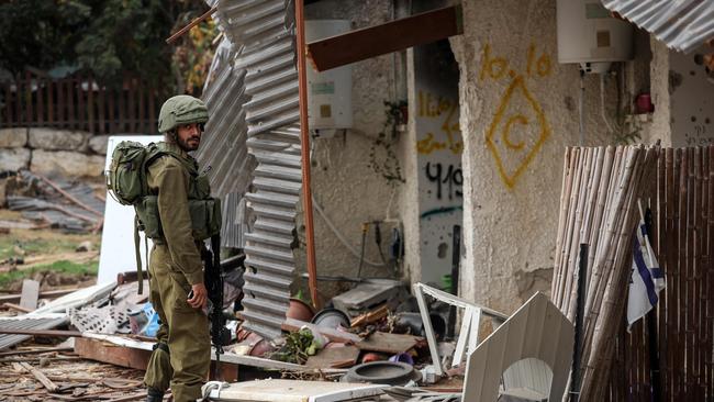 An Israeli soldier stands outside a destroyed home in Kibbutz Kfar Aza. Picture: Fadel Senna / AFP)