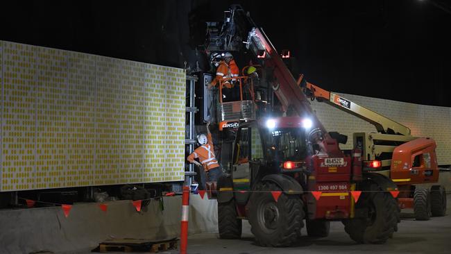 Workers install panels in the wall. Picture: Dylan Coker