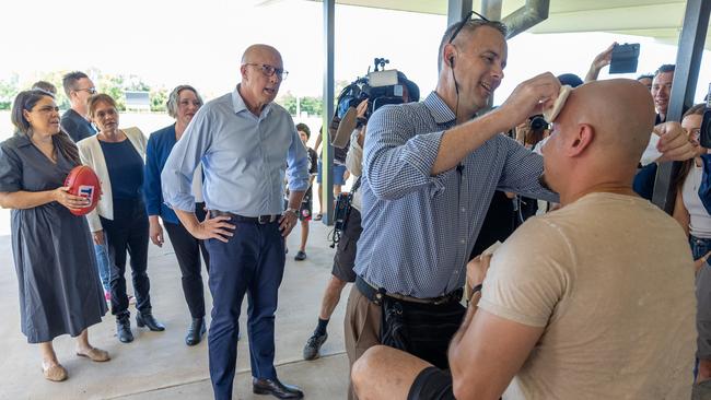 A Channel 10 cameraman gets treatment after Peter Dutton kicked a ball which injured him. Picture: NewsWire / Thomas Lisson