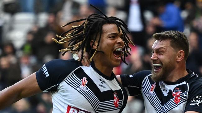 Dominic Young (L) celebrates after scoring at the Rugby League World Cup for England. (Photo by OLI SCARFF / AFP)