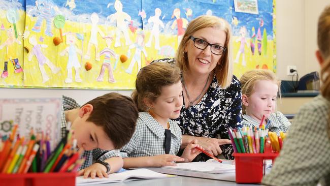 Teacher Monique Dickson with students Braxton Jarvis, Penny Waterhouse and Annabelle Pitt, all aged 6, at St Martin’s Catholic Primary School in Carina, Brisbane. Picture: Claudia Baxter