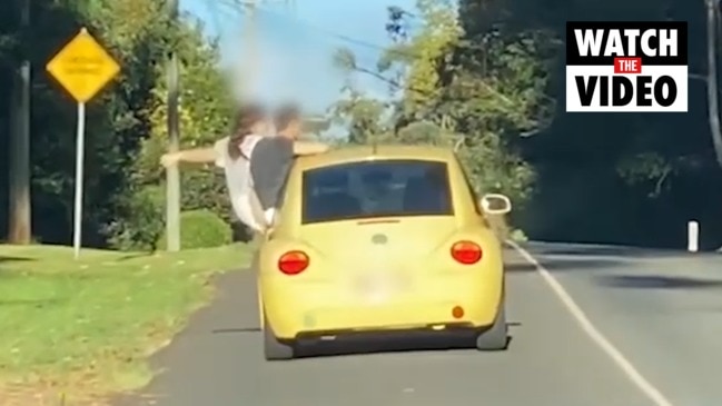 Qld police fine couple caught hanging out car window