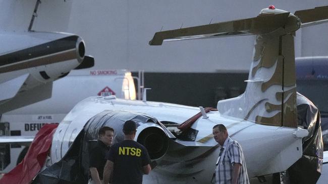 Investigators look at a crashed Learjet at Scottsdale Airport after it collided with a parked plane Monday, Feb. 10, 2025, in Scottsdale, Ariz. (AP Photo/Ross D. Franklin)