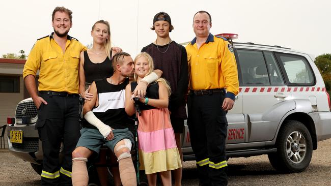 RFS firefighters Nathan Barnden and John Gallagher are reunited with Troy Pauling, his partner Jessica Gravener and their children. Picture: Jonathan Ng