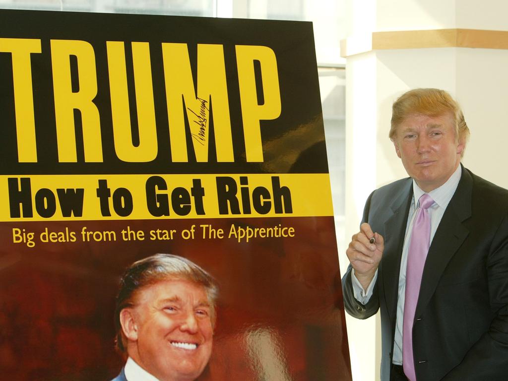 Donald Trump pauses for a moment after signing a poster depicting the cover of his new book, “How To Get Rich” on March 24, 2004 in New York City. Picture: Peter Kramer/Getty Images