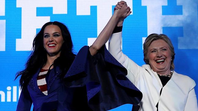 Democratic presidential nominee and former Secretary of State Hillary Clinton raises her arms with singer Katy Perry.