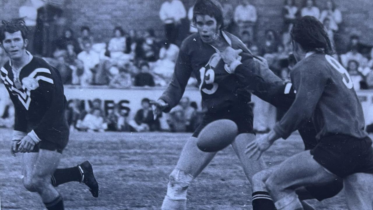 Newtown Lions' Gary (Barney) Meara (No. 13) passes to Graeme Wockner (No. 9) as Oakey Bears' centre Nev Tate (left) looks to cover defend in the 1973 Toowoomba Rugby League grand final.