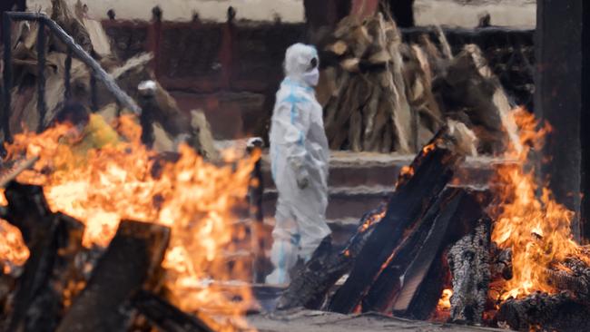 A man in PPE performs the last rites to his relative who died of coronavirus at a crematorium on April 20, 2021 in New Delhi, India. Picture: AFP