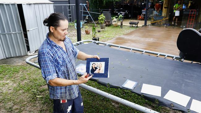 Chris “Kingy” King tries to save waterlogged photos of his wife and his children, after flood water from the Barron River tore through the lower lever of his Lake Placid Road home on Sunday night. Picture: Brendan Radke