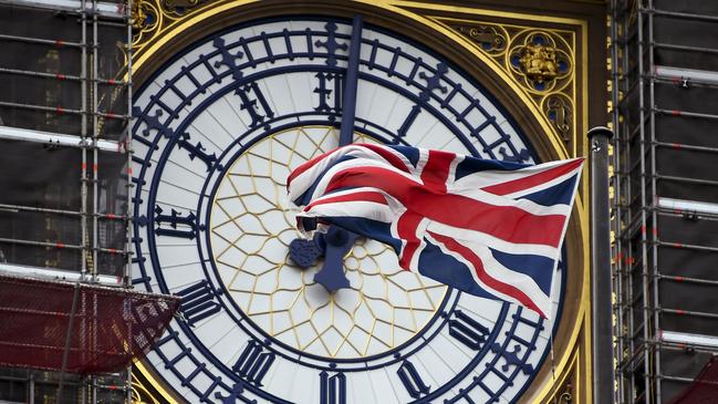 A Union flag waves against the backdrop of the clock facade of the Elizabeth Tower, which holds the bell known Big Ben in London.