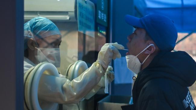 A health worker takes a swab sample from a man to test for the Covid-19 at a hospital in Wuhan, China's central Hubei proving. Picture: AFP.