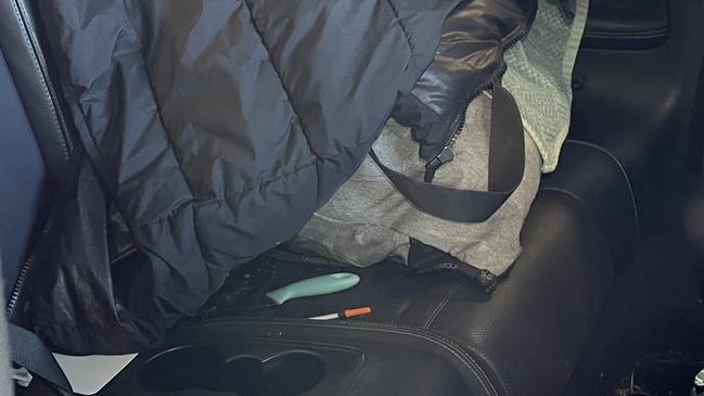 A syringe and knife in the back seat of a recovered stolen Mercedes-Benz C300 coupe.