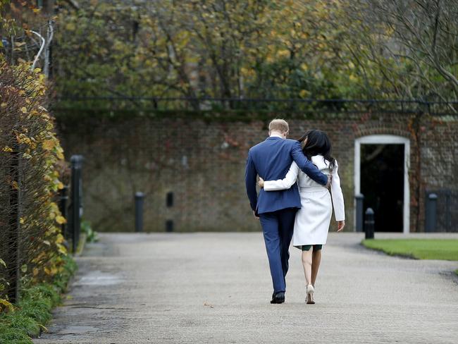 Prince Harry and Meghan Markle walk back into Kensington Palace after posing for the cameras. Picture: AP/Alastair Grant