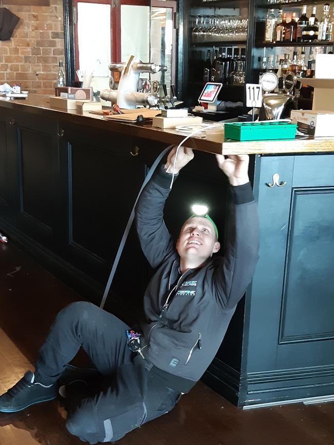 Sparky Lyle Rodgers installing lights underneath the bar at Enzo and Sons which he says owes him several thousand dollars for work conducted in June. Pic: Supplied