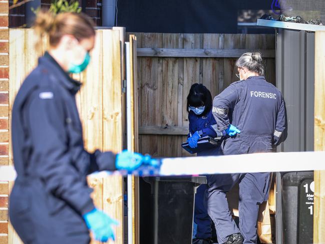 Police were seen examining cardboard boxes in the backyard on the home. Picture: David Caird