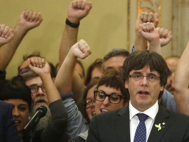 Catalan President Carles Puigdemont sings the Catalan anthem inside the parliament after a vote on independence in Barcelona, Spain. Picture: Manu Fernandez/AP