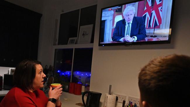 A family gathers around the television in Liverpool, north west England, to watch Britain's Prime Minister Boris Johnson announce the latest lockdown. Picture: AFP