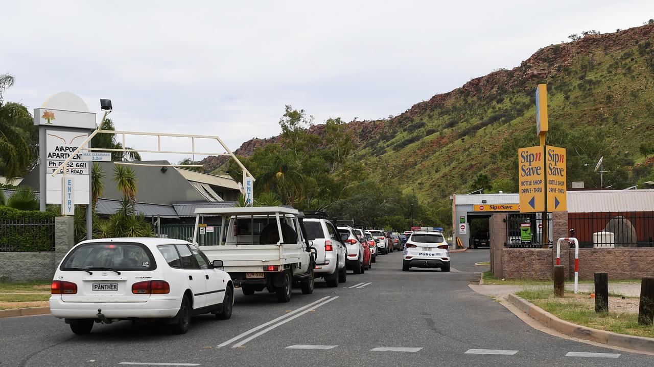 Police presence as cars line-up at the 3pm opening of the Gap View Hotel bottle shop in Alice Springs Wednesday, January 25,2023. Picture Mark Brake