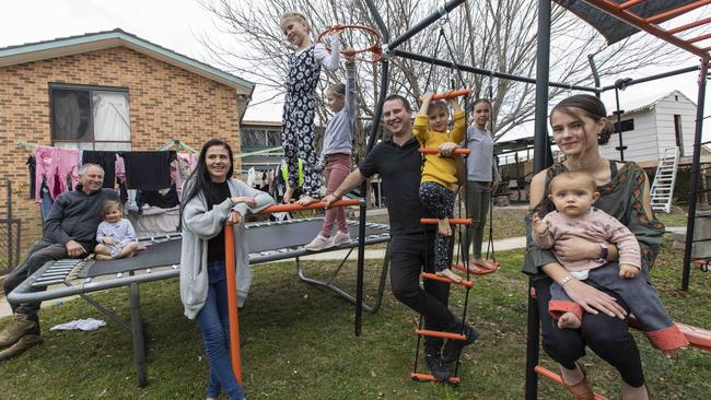 Steve and Kaleah Kolano with Steve’s dad Joe and their seven daughters, Lucia, 13, Amelia, 11, Olivia, 8, Arya, 7, Isabella, 6, Isla, 3, and Layla, 10 months at their home in the Canberra suburb of Calwell, which they are renovating. Picture: Sean Davey.